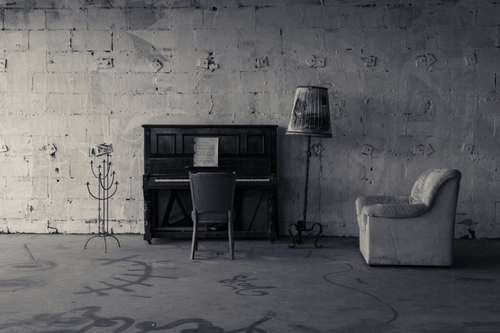 Captivating monochromatic interior of an abandoned building featuring a piano and vintage furniture.